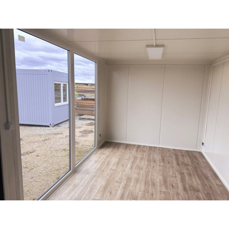 Contenedor elevado 7×3 m con grandes vitrinas, aire acondicionado y baño – módulo prefabricado tipo oficina o showroom