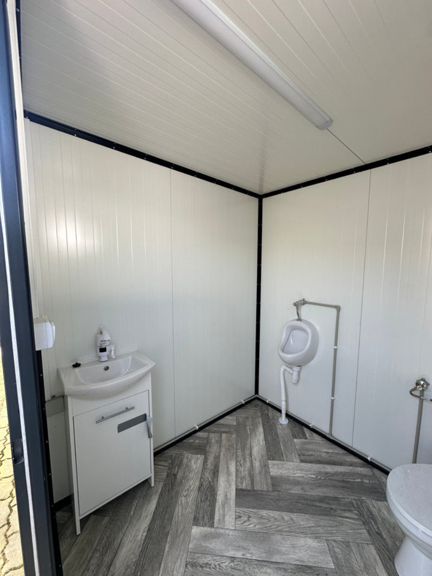 Contenedor sanitario 2,00 x 2,00 m con inodoro y urinario – módulo prefabricado compacto para obra y eventos